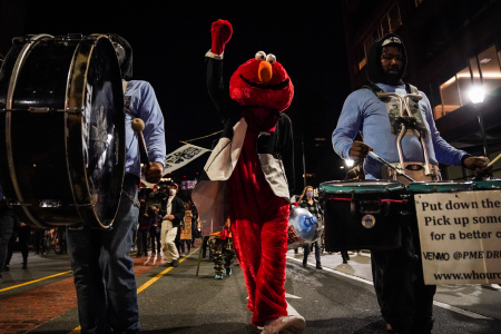 Philly Elmo, the leader of the drum line Positive Moment, raises his fist during a joint Black Lives Matter and Count Every Vote protest in Philadelphia, Pa. on Nov. 4, 2020.