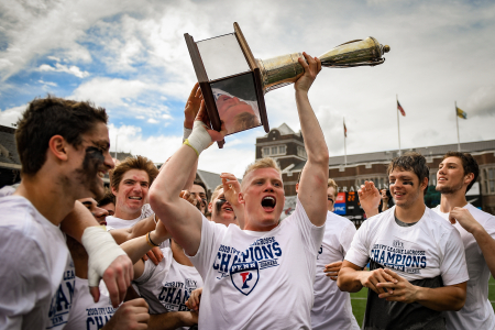 University of Pennsylvania midfielder Tyler Dunn lifts the Ivy League men's lacrosse regular season trophy after the Quakers defeated Dartmouth College, 22-6, at Franklin Field in Philadelphia, Pa. on April 20, 2019.