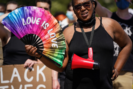 A protester fans herself during a Queer March for Black Lives demonstration outside the Philadelphia Museum of Art in Philadelphia, Pa. on June 21, 2020.