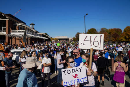 People are seen holding signs reading "No. 46!" and "TODAY WE CELEBRATE" during the celebrations of Joe Biden's election victory in Philadelphia, Pa. on Nov. 7, 2020. 