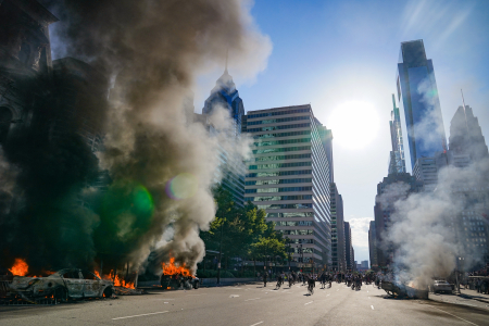 Cars burn on John F. Kennedy Boulevard as smoke rises in front of One Liberty Place in Philadelphia, Pa. on May 30, 2020.