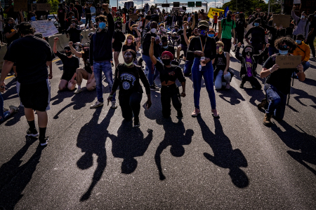 Protesters kneel and raise their fists after marching onto Interstate 676 in Philadelphia, Pa. on June 1, 2020.