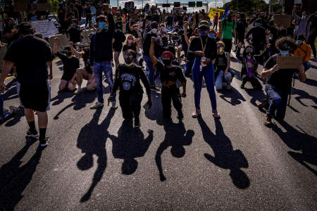 Protesters kneel and raise their fists after marching onto Interstate 676 in Philadelphia, Pa. on June 1, 2020.