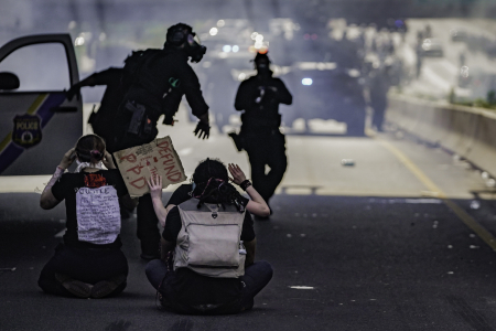 Protesters sit with their hands raised on Interstate 676 as Philadelphia Police officers and SWAT teams use tear gas and pepper spray to disperse the crowd in Philadelphia, Pa. on June 1, 2020.