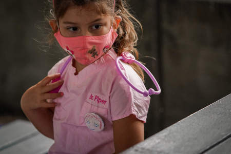 Dressed up as a doctor for Heroes Day, a camper in the five to six-year-old division waits for lunch on Aug. 7, 2020. Asphalt Green Summer Day Camp has many theme days throughout the summer each year, but management added Heroes Day to honor the healthcare and other essential workers that had been on the front lines of the pandemic.