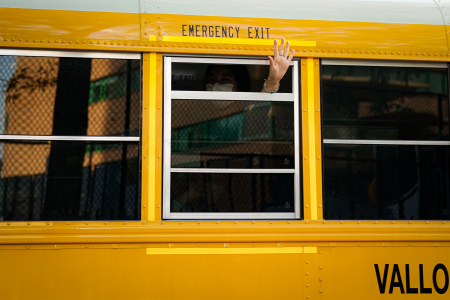 Karin Ueda, a counselor in the nine to 13-year-old division, waves as the final camp bus departs from the site on the last day of camp on Aug. 21, 2020.