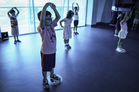 In the blue room - named for its distinct colored lighting - campers stand on socially distanced spots while participating in dance class on July 16, 2020.