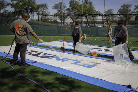 Members of the maintenance staff clean the Slip N' Slides in between activity periods on Aug. 20, 2020. To enable campers to participate in water activities while still taking measures to prevent the potential spread of COVID-19, the maintenance staff washed down the water slides in between every period.  