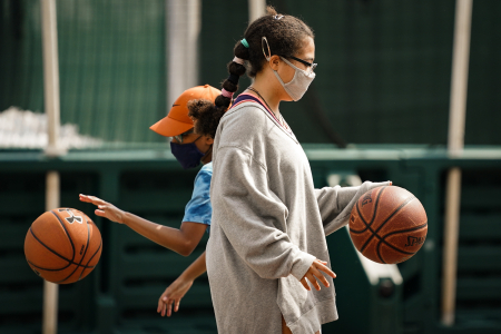 Campers in the nine to 13-year-old division practice dribbling a basketball on July 22, 2020. Masks were not required for campers during single-group outdoor activities, but many often wore them anyway.