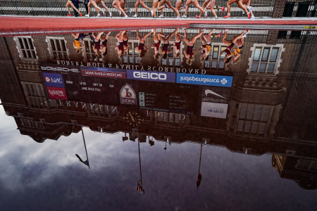 Runners, seen reflected in the steeplechase pool, compete in the women's 1500m during the Philadelphia Big 5 Meet at Franklin Field in Philadelphia, Pa. on April 3, 2021.