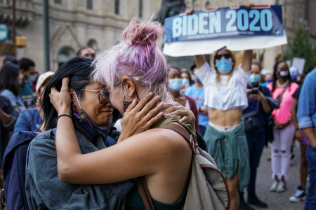 A couple embraces in the crowd as the celebrations of Joe Biden's election victory take place outside the City Hall building in Philadelphia, Pa. on Nov. 7, 2020.