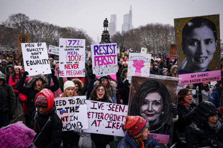 Demonstrators cheer and hold up signs outside the Philadelphia Museum of Art during the annual Women's March on Philadelphia in Philadelphia, Pa. on Jan. 19, 2020.