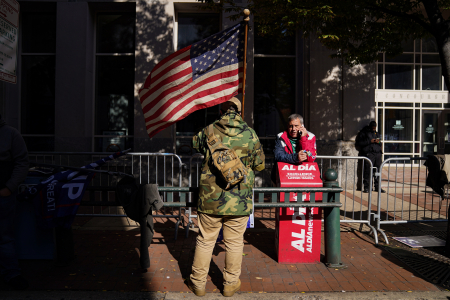 A supporter of President Donald Trump folds a Keep America Great flag prior to a demonstration outside the Pennsylvania Convention Center in Philadelphia, Pa. on Nov. 6, 2020.